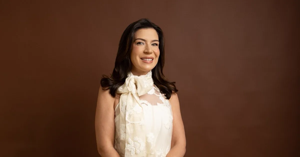 Dra. Ylls Brilhante em retrato profissional para artigo educativo sobre espondilite anquilosante e dor lombar inflamatória.